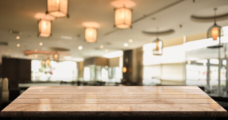 Empty wooden table top with lights bokeh on blur Chinese restaurant background.