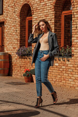young beautiful brunette walking around the city.denim jacket,urban backpack