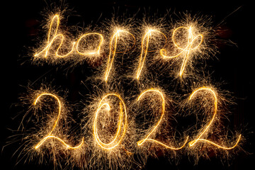 Happy New Year 2022. Happy 2022 written with sparkling sparklers isolated on black background with copy space for text. Glowing, creative overlay template for holiday greeting card or banner design