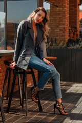 Close up portrait of a young woman sitting at the table in a street cafe