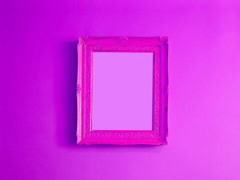 Hot pink antique empty photo frame isolated on gradient purple colored wall