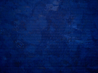 Fototapeta na wymiar Background from the embossed surface of roughly painted blue paint with uneven saturation