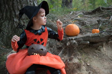 Beautiful girl witch conjures. The girl is dressed in a witch costume for the Halloween holiday....
