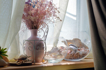 Beautiful dried flower bouquet in pink porcelain vase windowsill