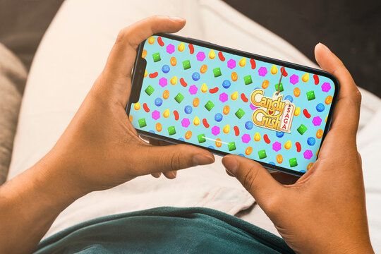 Female hand holding a smartphone with Candy Crush Saga mobile game app on the screen. Rio de Janeiro, RJ, Brazil. September 2021.