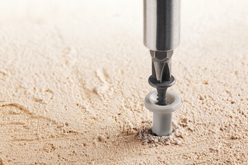 screwdriver screw and dowel in a concrete wall background