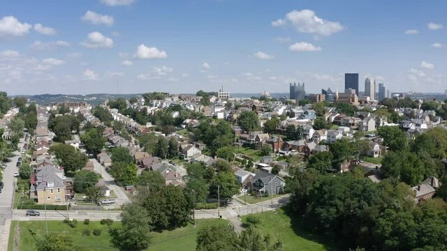 A rising summer aerial establishing shot of a Mount Washington neighborhood overlooking the city of Pittsburgh.  	
