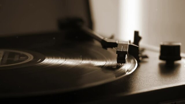 A Record Playing on a Vinyl Turntable Deck. Closeup. Sepia Tone. 4K Resolution.