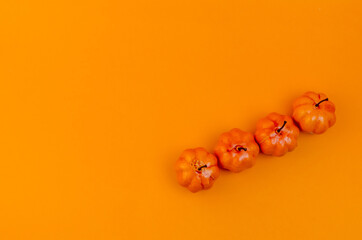flatlay small orange pumpkins on orange background