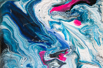 Obraz premium Texture in the style of fluid art. Abstract background with paint mixing effect. Liquid acrylic paint background. Blue, black, white and pink colors.