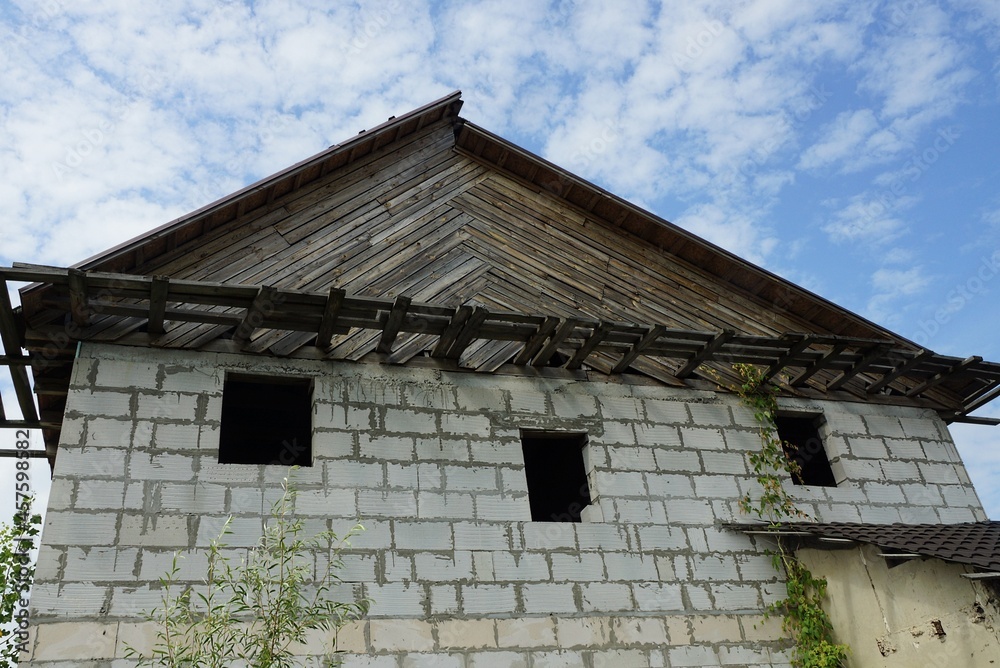 Canvas Prints abandoned private white brick house with empty windows with gray wooden loft on a background of blue