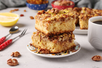 Homemade lemon pie with raisins and nuts on a light gray background