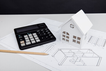 Fototapeta na wymiar Model of house and calculator on architectural plan. House building costs