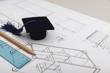 Mechanical drawings and graduation cap close-up. Engineering education concept