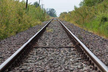 Fototapeta premium Railroad tracks, railroad rails, two parallel rails on which the train runs. A straight road somewhere far away