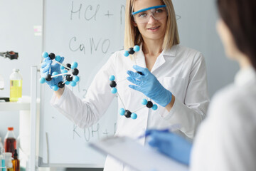 In hands of woman, scientist holds molecular model in laboratory closeup