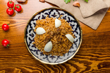 pilaf with beef top view on wooden table