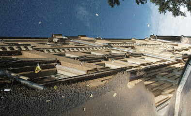 A puddle on the street and a reflection of a multi-storey residential building