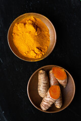 Directly above shot of Turmeric roots and powder in bowls