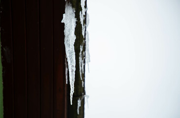 A big beautiful icicle hanging from the roof 