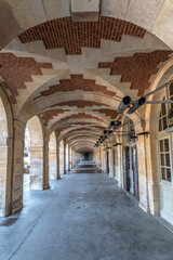 Passage sous les voûtes en brique autour de la place des Vosges dans le centre de Paris
