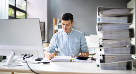 Young Businessman Working At Office With Stack Of Folders