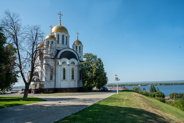 Fototapeta na wymiar St. George's Church on Glory Square y Behind - the great Volga River