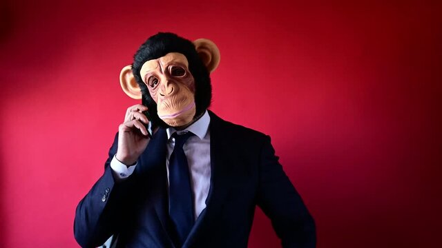 Businessman in monkey mask talking on smartphone.