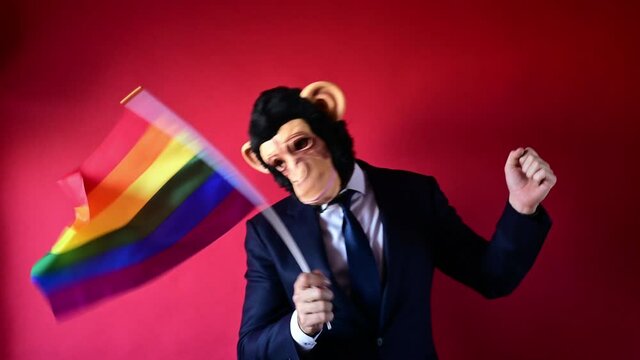 Businessman with monkey mask and waving multicolored flag