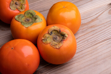 木の板の上においた柿の写真