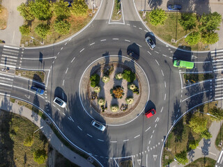 Aerial drone view of roundabout in the city. Cars and trucks moving fast. Traffic on roundabout in...