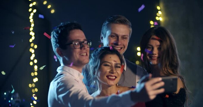 a group of young people smiling and throwing confetti, taking selfies for the new year, Christmas holiday