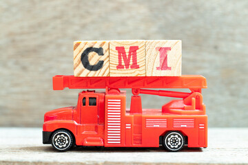 Fire ladder truck hold letter block in word CMI (Abbreviation of Cost management index, Co-managed inventory,Customer Managed Inventory or case mix index on wood background