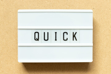 Lightbox with word quick on wood background