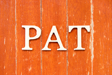 Alphabet letter in word PAT (abbreviation of Profit after tax or Preferred activity time) on old red color wood plate background