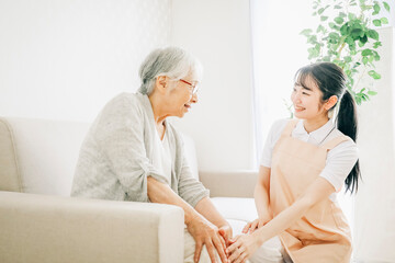 Obraz premium 訪問介護・膝をおさえる高齢者女性（アジア人・中国人・日本人・韓国人）