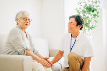 Obraz premium 訪問介護する男性と高齢者（笑顔） 