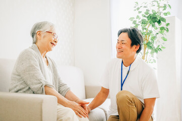 Fototapeta premium 訪問介護する男性と高齢者（笑顔） 