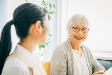 Obraz premium 笑顔の高齢者女性と女性スタッフ 