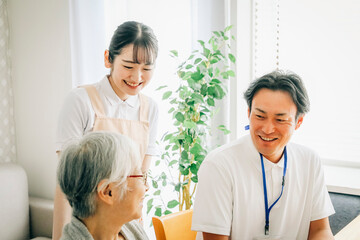 高齢者と話す男女のスタッフ
