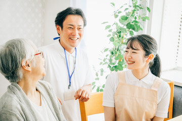 Obraz premium 高齢者と話す男女のスタッフ 