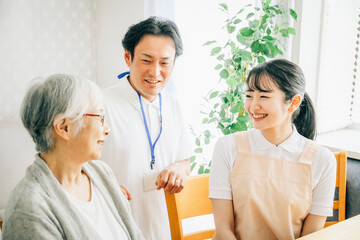 高齢者と話す男女のスタッフ
