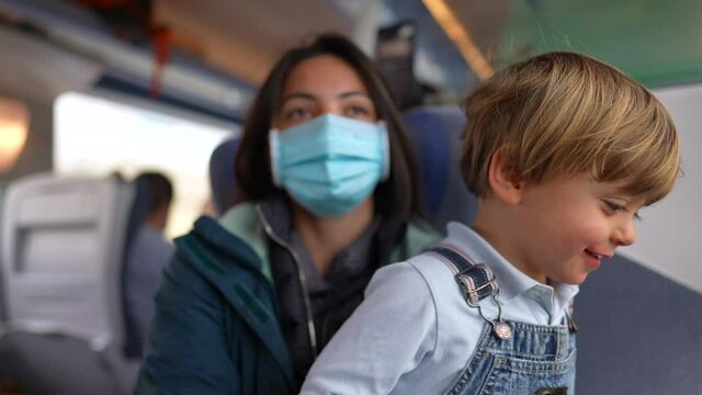 Mother And Toddler Travelling By Train Wearing Surgical Face Mask