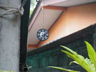 Hanging yin yang symbol, natural blurred background