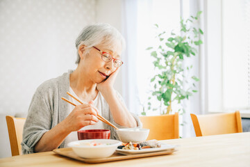 食事をする高齢者女性（痛い）

