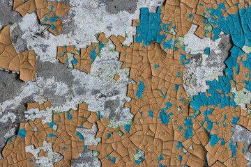 Naklejka premium Peeling paint on the wall. Old concrete wall with cracked flaking paint. Weathered rough painted surface with patterns of cracks and peeling. High resolution texture for background and design. Closeup