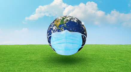 Fototapeta na wymiar Earth wearing a surgeon mask to fight against Corona virus or COVID-19 on Green Background. World Corona virus attack and Earth Day concept. Elements furnished by NASA.