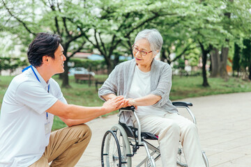 車椅子に乗った高齢者女性と男性スタッフ
