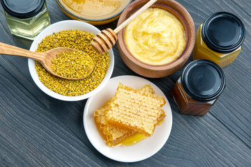 Fresh flower honey of different varieties, pollen and honeycomb with spoons on a wooden background. Organic Vitamin Health Food