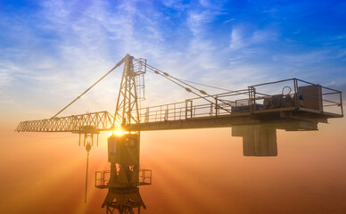 Construction tower crane on the background of the morning sky.